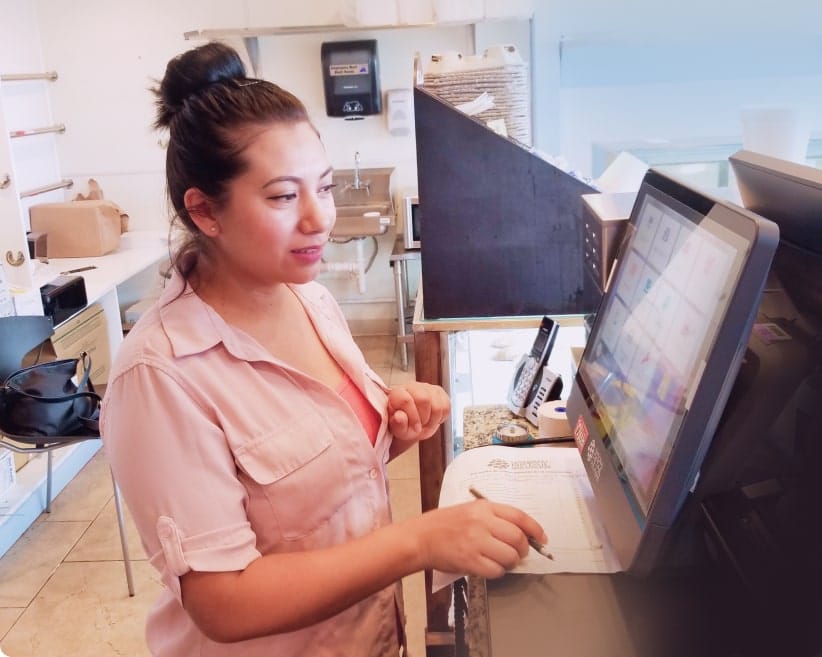 Merchant behind the counter with a pos machine