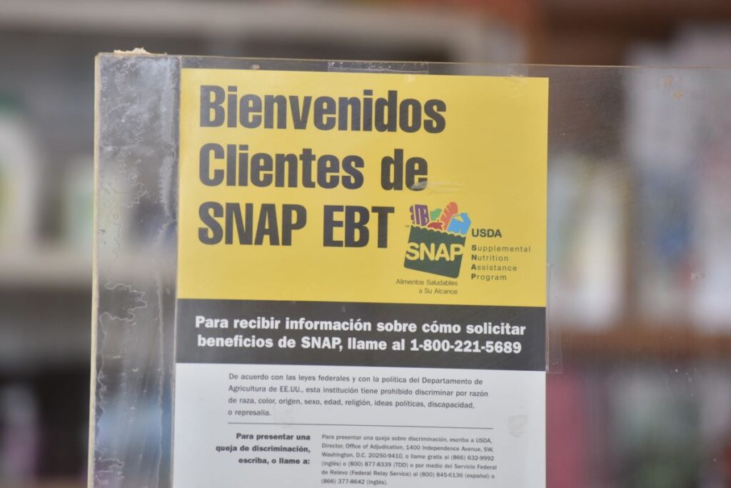 EBT sign in Spanish on an entrance at a deli in Newark