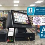 A National Retail Solutions POS system on a store counter with a BBB Accredited Business logo and A+ rating overlay